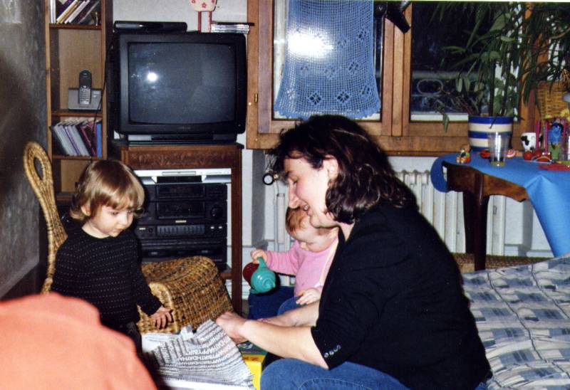 2006_02_Carla_Christine Christine ouvre tous ses cadeaux sous le regard attentif de Carla pendant que je m'amuse avec mon biberon.